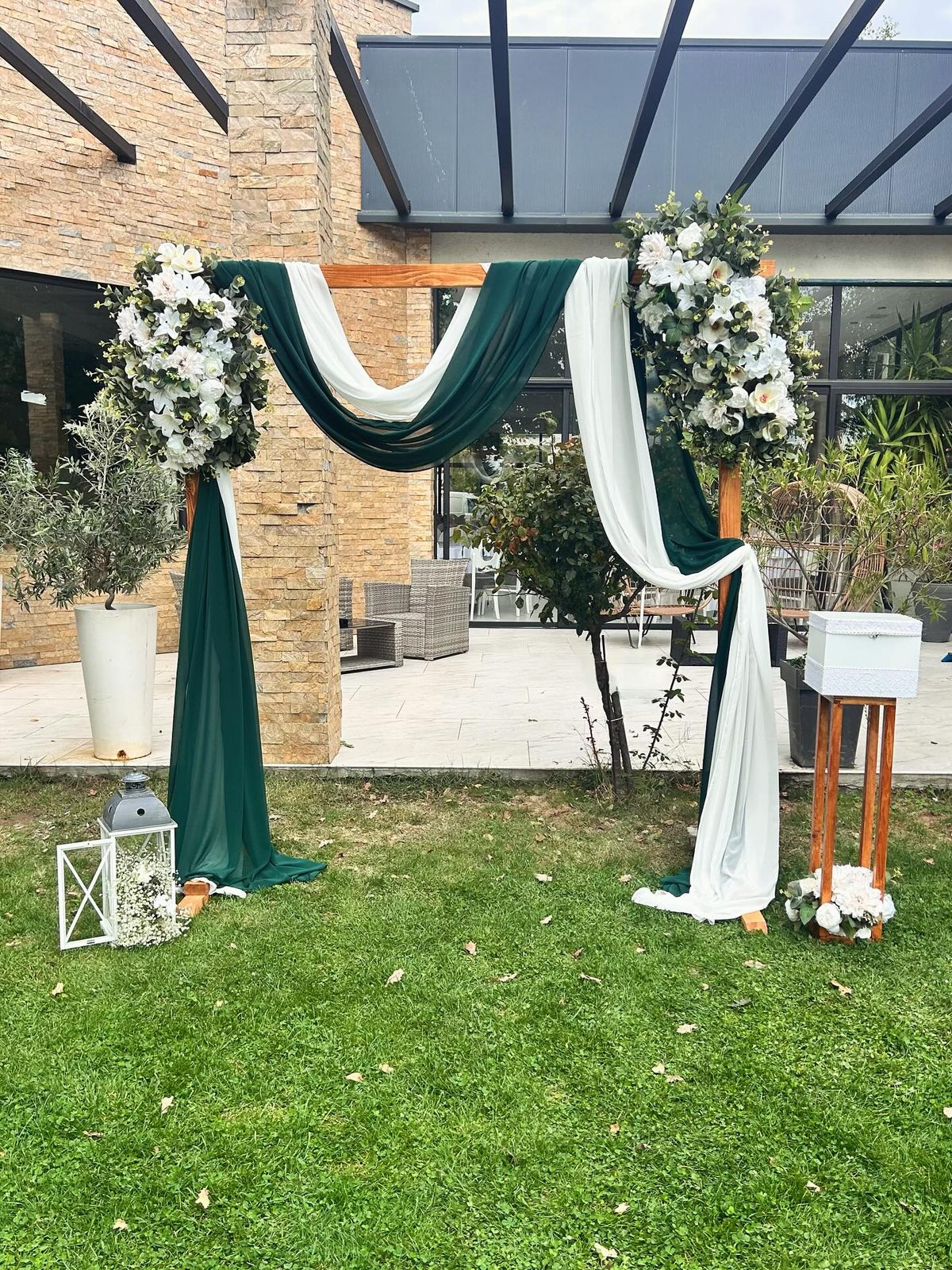 Venčani luk sa zelenom i belom draperijom u dvorištu